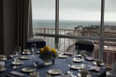 a dining table with a view of the beach at Crowne Plaza Ventura Beach by IHG in Ventura