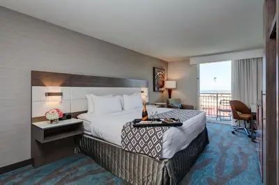 a hotel room with a bed and a balcony at Crowne Plaza Ventura Beach by IHG in Ventura