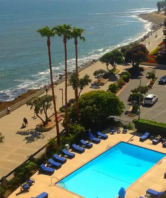 an overhead view of a swimming pool with chairs and a beach at Crowne Plaza Ventura Beach by IHG in Ventura