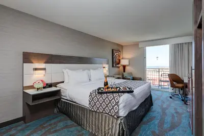 a hotel room with a bed and a balcony at Crowne Plaza Ventura Beach by IHG in Ventura