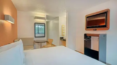 a bedroom with a bed and a tv on the wall at Motel 6-Los Angeles, CA - Los Angeles - LAX in Inglewood