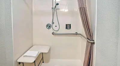 a bathroom with a shower with a toilet and a stool at Motel 6-Los Angeles, CA - Los Angeles - LAX in Inglewood