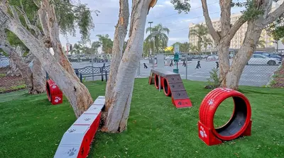 a park with red benches next to a tree at Motel 6-Los Angeles, CA - Los Angeles - LAX in Inglewood