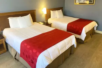 a hotel room with two beds with red and white sheets at Ramada by Wyndham Los Angeles/Wilshire Center in Los Angeles