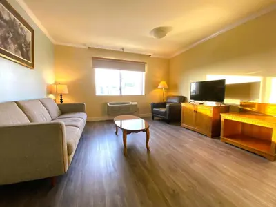 a living room with a couch and a tv at Ramada by Wyndham Los Angeles/Wilshire Center in Los Angeles