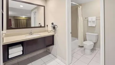 a bathroom with a sink and a toilet and a mirror at Best Western Pasadena Royale Inn & Suites in Pasadena