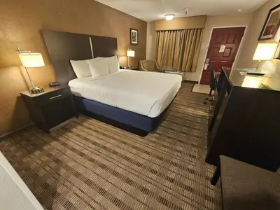 a hotel room with a large bed and a desk at Best Western Pasadena Royale Inn & Suites in Pasadena
