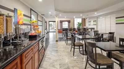 a restaurant with tables and chairs and a bar at Best Western Pasadena Royale Inn & Suites in Pasadena