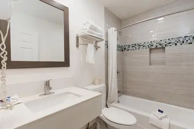 a bathroom with a sink and a toilet and a tub at Americas Best Value Inn & Suites Anaheim in Anaheim