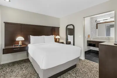 a bedroom with a large white bed and a sink at Sonesta ES Suites Chatsworth in Chatsworth