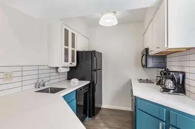 a kitchen with blue cabinets and a black refrigerator at Sonesta ES Suites Chatsworth in Chatsworth
