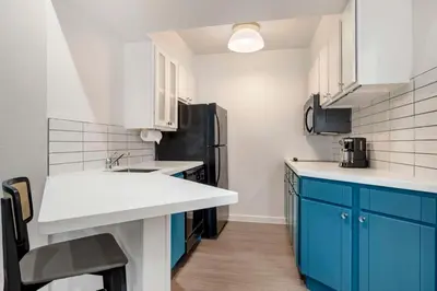 a kitchen with blue cabinets and a black refrigerator at Sonesta ES Suites Chatsworth in Chatsworth