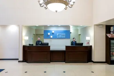 two people sitting at a reception desk in a lobby at Holiday Inn Express Hotel & Suites Los Angeles Airport Hawthorne by IHG in Hawthorne