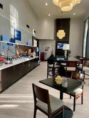 a restaurant with tables and chairs and a counter at Holiday Inn Express Hotel & Suites Hermosa Beach by IHG in Hermosa Beach