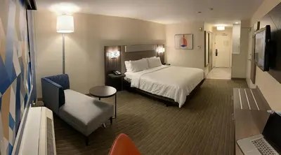 a hotel room with a bed and a chair at Holiday Inn Express Hotel & Suites Hermosa Beach by IHG in Hermosa Beach