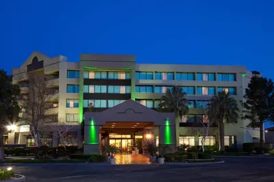 a building with green lights on it at night at Holiday Inn Palmdale-Lancaster by IHG in Palmdale