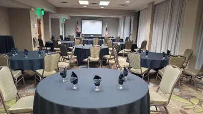 a conference room with tables and chairs with hats on them at Holiday Inn Palmdale-Lancaster by IHG in Palmdale