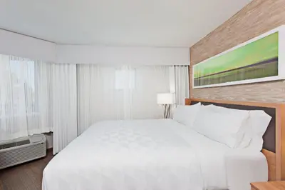 a large white bed in a hotel room at Holiday Inn Palmdale-Lancaster by IHG in Palmdale