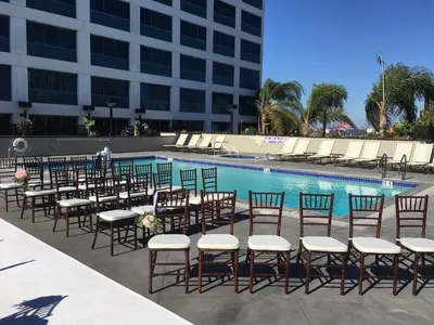 a row of tables and chairs next to a swimming pool at Crowne Plaza Hotel Los Angeles Harbor by IHG in San Pedro