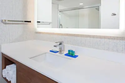 a bathroom with a white sink and a mirror at Holiday Inn Express & Suites Pasadena - Los Angeles by IHG in Pasadena