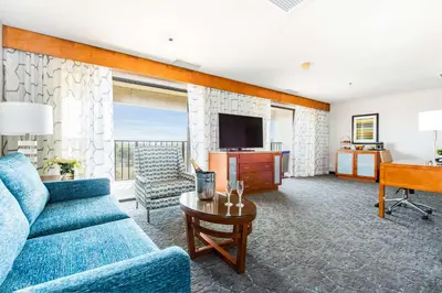 a living room with a blue couch and a television at DoubleTree by Hilton Carson in Carson