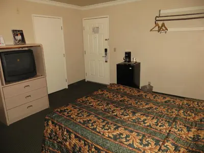 a hotel room with a bed and a tv at Super 8 by Wyndham Hollywood/LA Area in Los Angeles