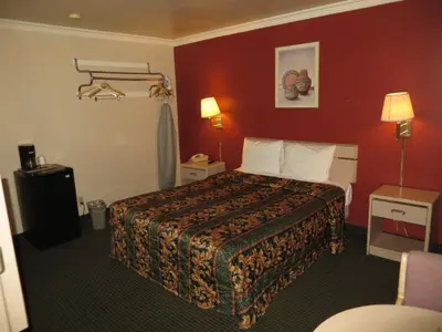 a hotel room with a bed and red walls at Super 8 by Wyndham Hollywood/LA Area in Los Angeles