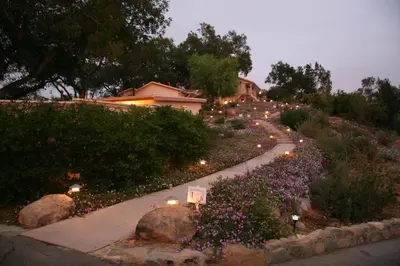 a walkway with flowers and lights in a yard at Ojai Retreat & Inn in Ojai