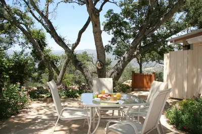 a table and chairs on a patio with a tree at Ojai Retreat & Inn in Ojai