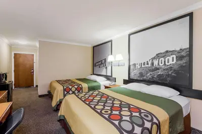 a hotel room with two beds and a large screen at Super 8 by Wyndham Los Angeles Downtown in Los Angeles