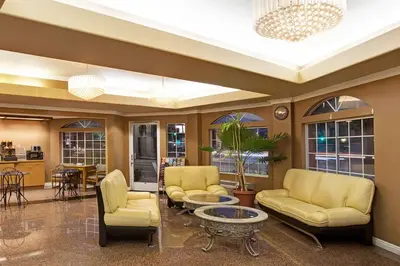 a living room with yellow chairs and a table at Super 8 by Wyndham Los Angeles Downtown in Los Angeles