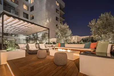 a patio with couches and tables and a building at Hollywood Panoramic Views, Pool, Gym & Free parking! in Los Angeles