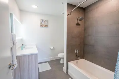 a bathroom with a tub and a toilet and a sink at Hollywood Panoramic Views, Pool, Gym & Free parking! in Los Angeles