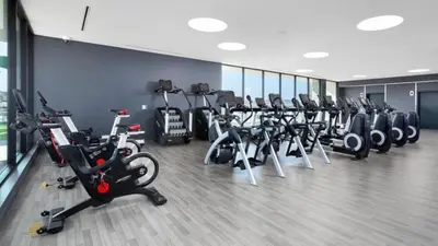 a gym with a row of exercise bikes and treadms at Hollywood Panoramic Views, Pool, Gym & Free parking! in Los Angeles