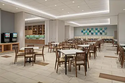 a dining room filled with tables and chairs at Hyatt House at Anaheim Resort/Convention Center in Anaheim