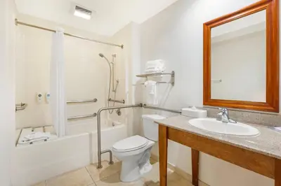 a bathroom with a sink and a toilet and a tub at Comfort Inn Cockatoo Near LAX Airport in Hawthorne