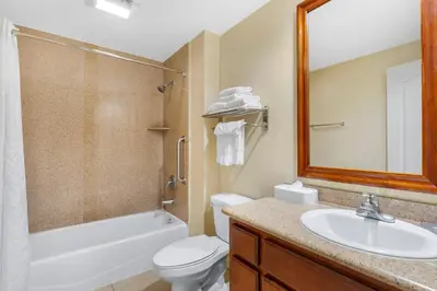 a bathroom with a sink and a toilet and a mirror at Comfort Inn Cockatoo Near LAX Airport in Hawthorne