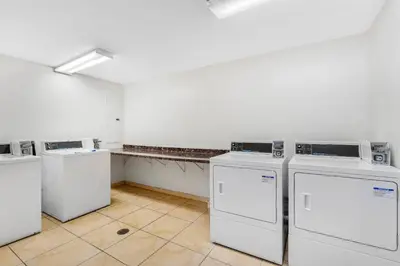 a laundry room with four washing machines in it at Comfort Inn Cockatoo Near LAX Airport in Hawthorne