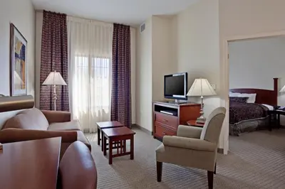 a living room with a couch and a television in a hotel room at Staybridge Suites Palmdale by IHG in Palmdale