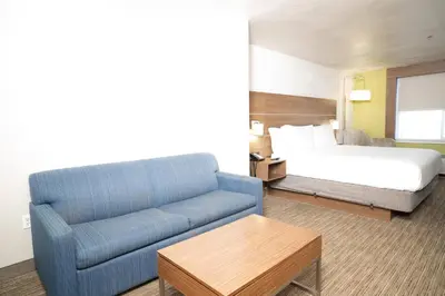 a hotel room with a couch and a bed at Holiday Inn Express Hotel & Suites Hesperia by IHG in Hesperia