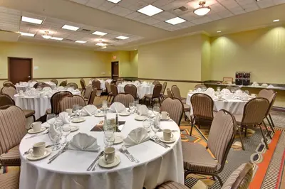a banquet room with white tables and chairs at Holiday Inn & Suites Bakersfield by IHG in Bakersfield