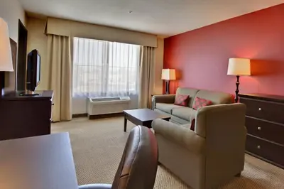 a living room with a couch and a tv at Holiday Inn & Suites Bakersfield by IHG in Bakersfield