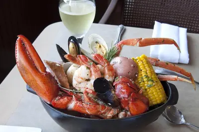 a bowl of seafood on a table with a glass of milk at The Queen Mary in Long Beach
