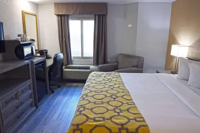 a hotel room with a bed and a desk and a television at Baymont by Wyndham Barstow Historic Route 66 in Barstow