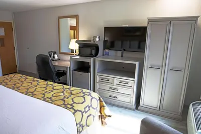 a hotel room with a bed and a desk with a microwave at Baymont by Wyndham Barstow Historic Route 66 in Barstow
