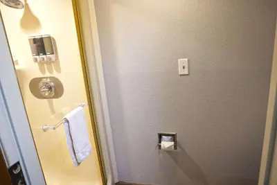 a bathroom with a toilet paper dispenser and a towel at Baymont by Wyndham Barstow Historic Route 66 in Barstow