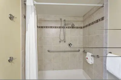 a bathroom with a shower with a tub and a sink at Baymont by Wyndham Barstow Historic Route 66 in Barstow