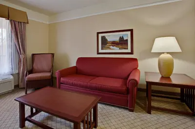 a living room with a red couch and two chairs at Holiday Inn Express Hotel & Suites San Dimas by IHG in San Dimas