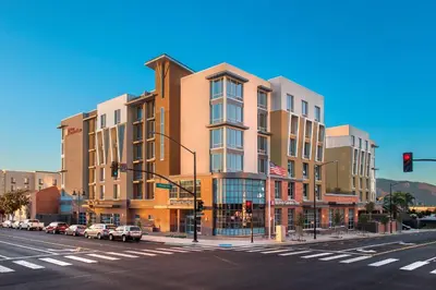 a building on the corner of a street with cars parked outside at Hilton Garden Inn Burbank Los Angeles in Burbank