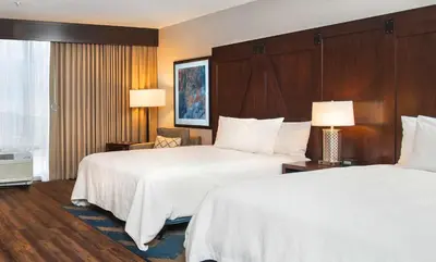 a hotel room with two beds and two lamps at Hilton Garden Inn Burbank Los Angeles in Burbank